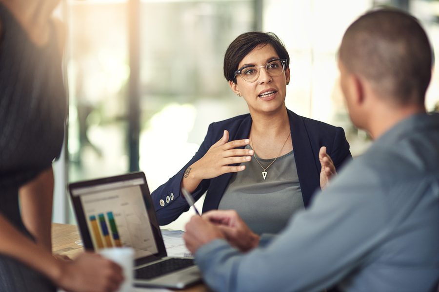A mentor coaching a colleague at a workstation